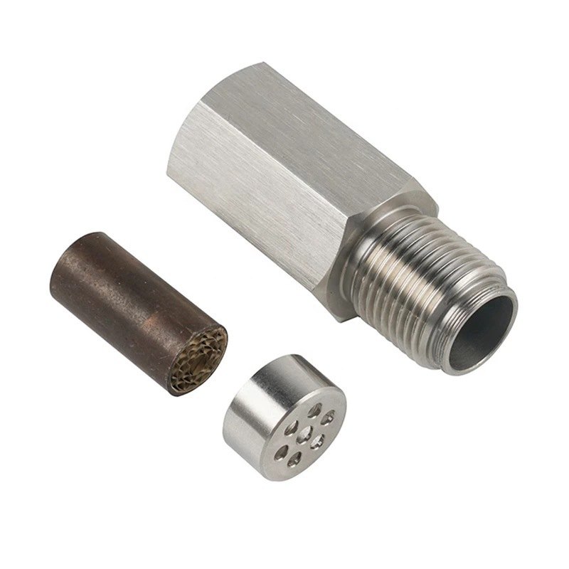 Mini catalytic converter O₂ sensor spacer in stainless steel, shown with the ceramic honeycomb catalyst element that sits inside it